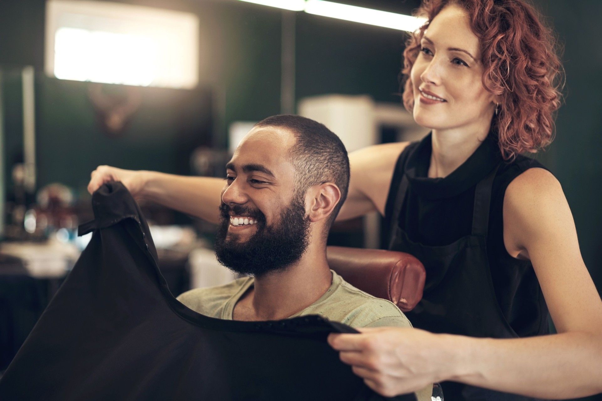 Shot of a handsome young man sitting and getting his hair styled by his hairdresser